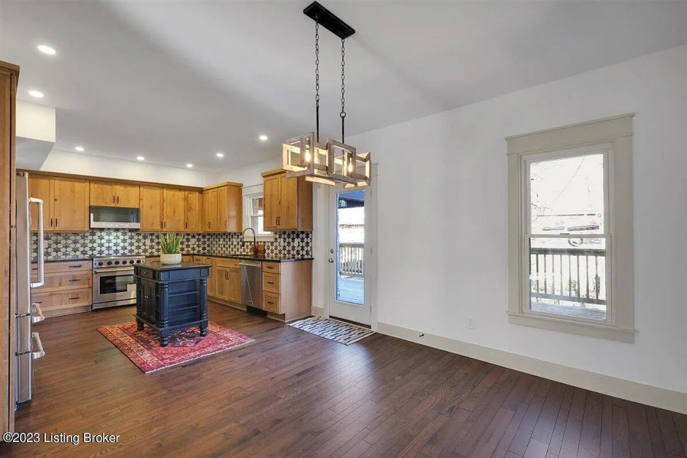 Inspiration for a mid-sized transitional l-shaped medium tone wood floor kitchen remodel with an undermount sink, shaker cabinets, light wood cabinets and an island