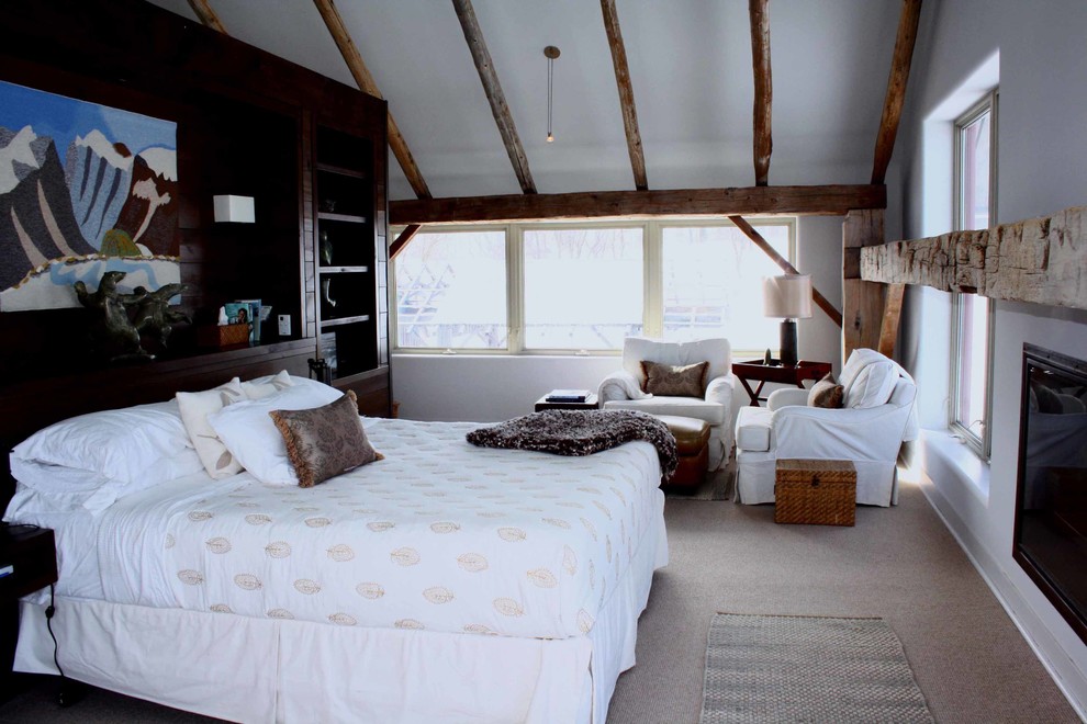 Large country loft-style bedroom in Toronto with white walls, carpet and a standard fireplace.