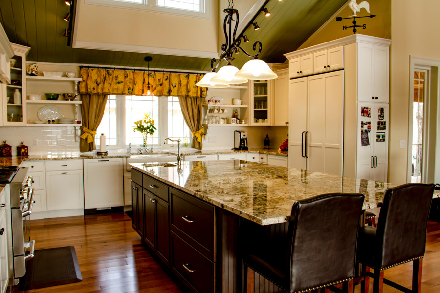 Inspiration for a large transitional u-shaped medium tone wood floor and brown floor open concept kitchen remodel in Denver with a farmhouse sink, shaker cabinets, white cabinets, granite countertops, white backsplash, subway tile backsplash, stainless steel appliances and an island