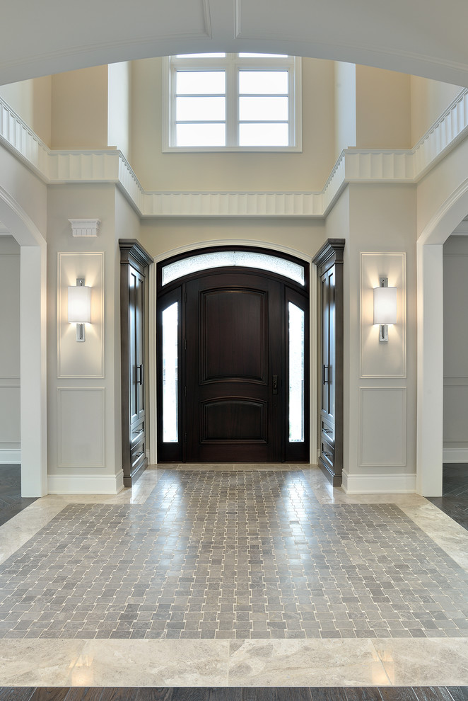 Photo of a traditional entryway in Toronto with a dark wood front door and grey floor.