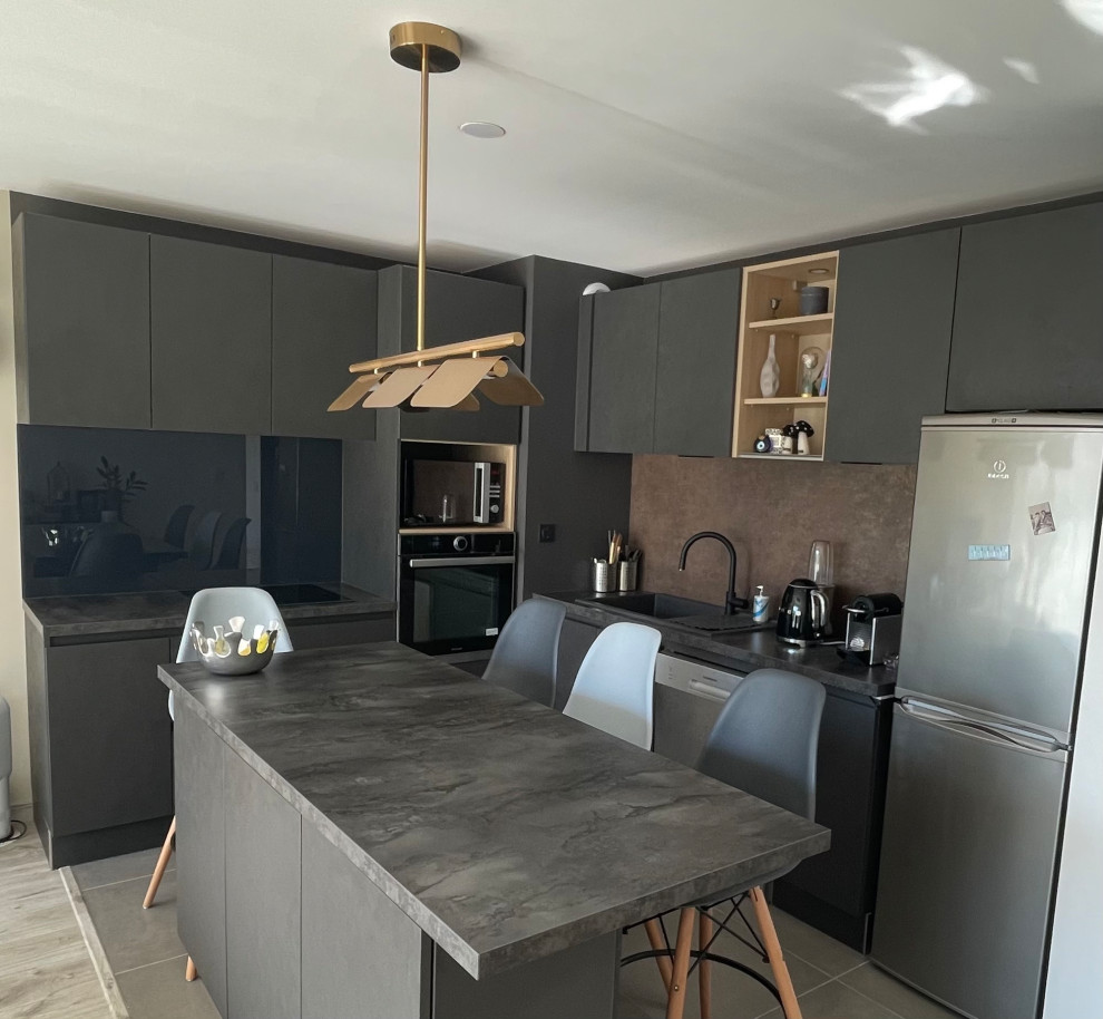 Inredning av ett modernt mellanstort grå grått kök, med en undermonterad diskho, luckor med profilerade fronter, skåp i rostfritt stål, bänkskiva i kvartsit, grått stänkskydd, stänkskydd i glaskakel, integrerade vitvaror, klinkergolv i porslin, en köksö och grått golv