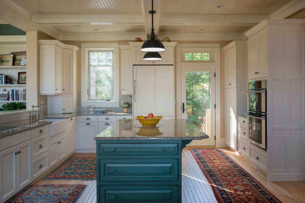 Design ideas for a mid-sized traditional u-shaped eat-in kitchen in Boston with a farmhouse sink, recessed-panel cabinets, white cabinets, granite benchtops, grey splashback, white appliances, light hardwood floors and with island.