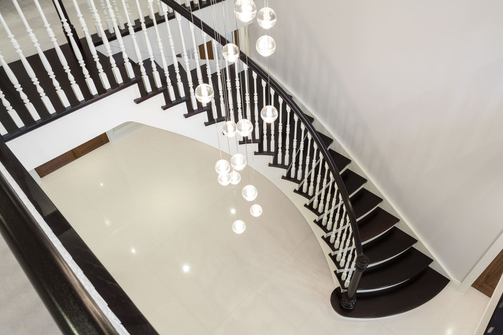 This is an example of a traditional wood curved wood railing staircase in London with wood risers.