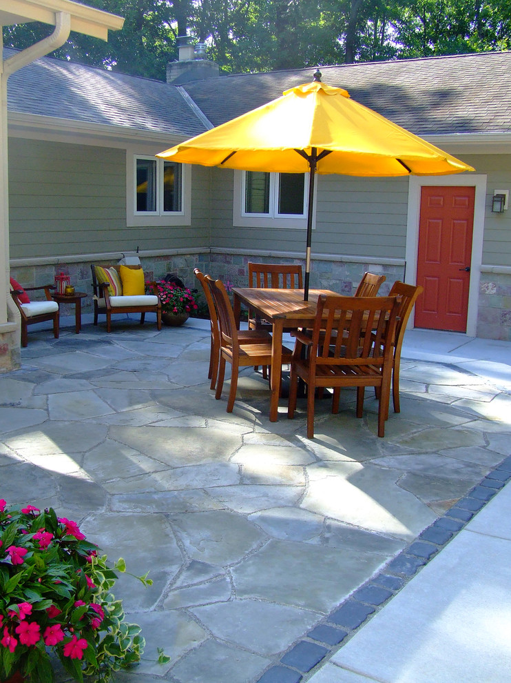 This is an example of a mid-sized contemporary backyard patio in Milwaukee with a fire feature, natural stone pavers and no cover.