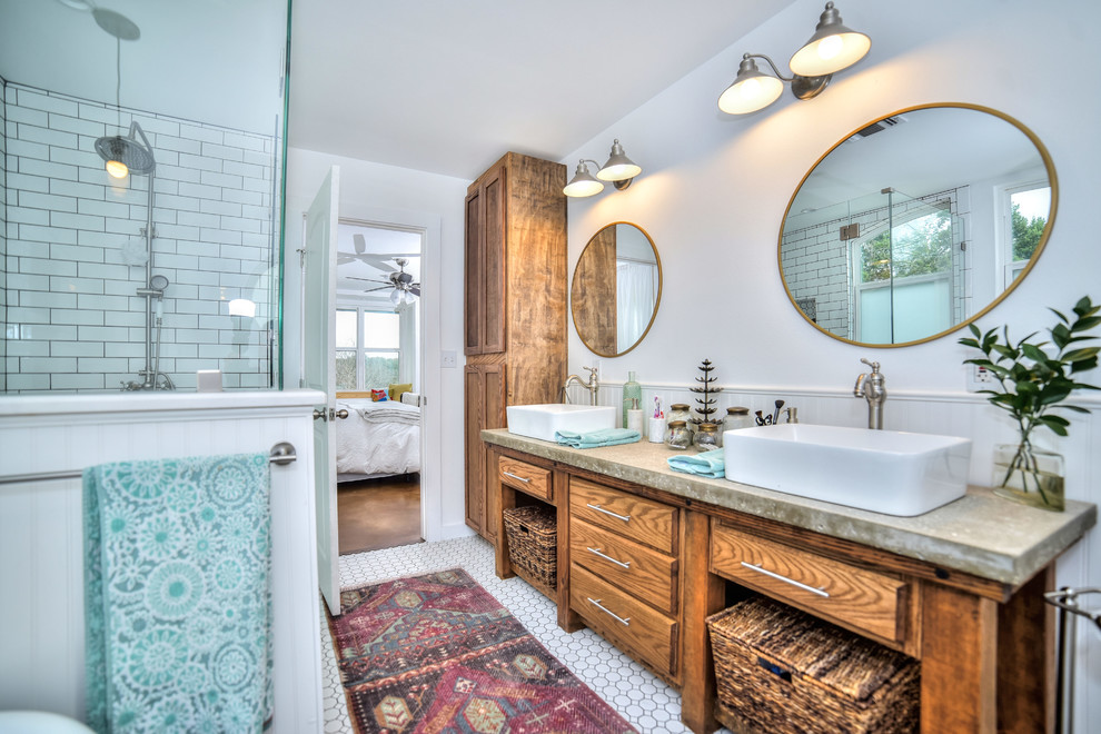 Photo of a mid-sized arts and crafts master bathroom in Austin with furniture-like cabinets, light wood cabinets, a claw-foot tub, a curbless shower, a two-piece toilet, white tile, subway tile, white walls, ceramic floors, a vessel sink, concrete benchtops, white floor and a hinged shower door.