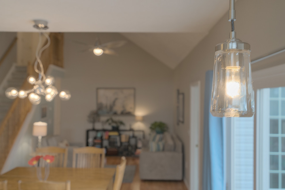 Home design - mid-sized transitional u-shaped light wood floor home design idea with an undermount sink, shaker cabinets, white cabinets, quartz countertops, beige backsplash, glass tile backsplash, stainless steel appliances and a peninsula