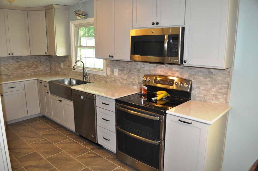 This is an example of a small modern galley eat-in kitchen in Charleston with white cabinets and stainless steel appliances.
