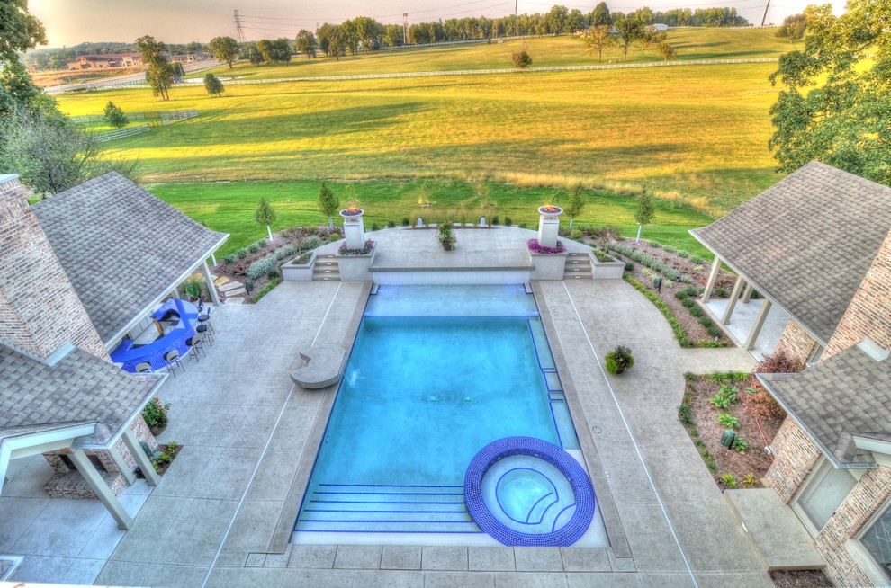 Large transitional backyard concrete paver and rectangular natural hot tub photo in Cedar Rapids