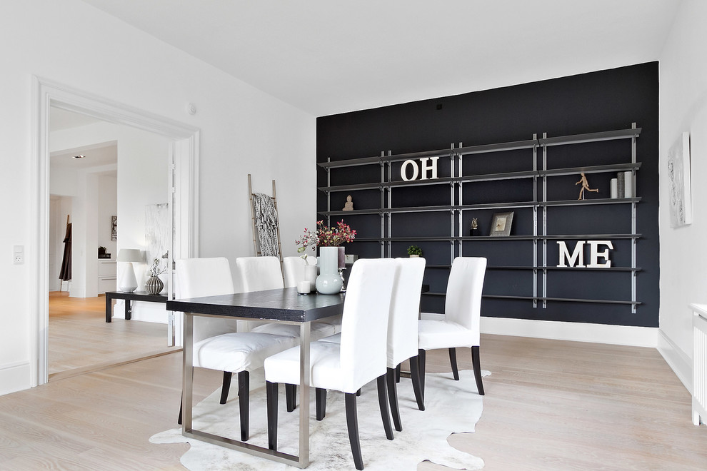 Inspiration for a mid-sized scandinavian separate dining room in Copenhagen with black walls, light hardwood floors and beige floor.
