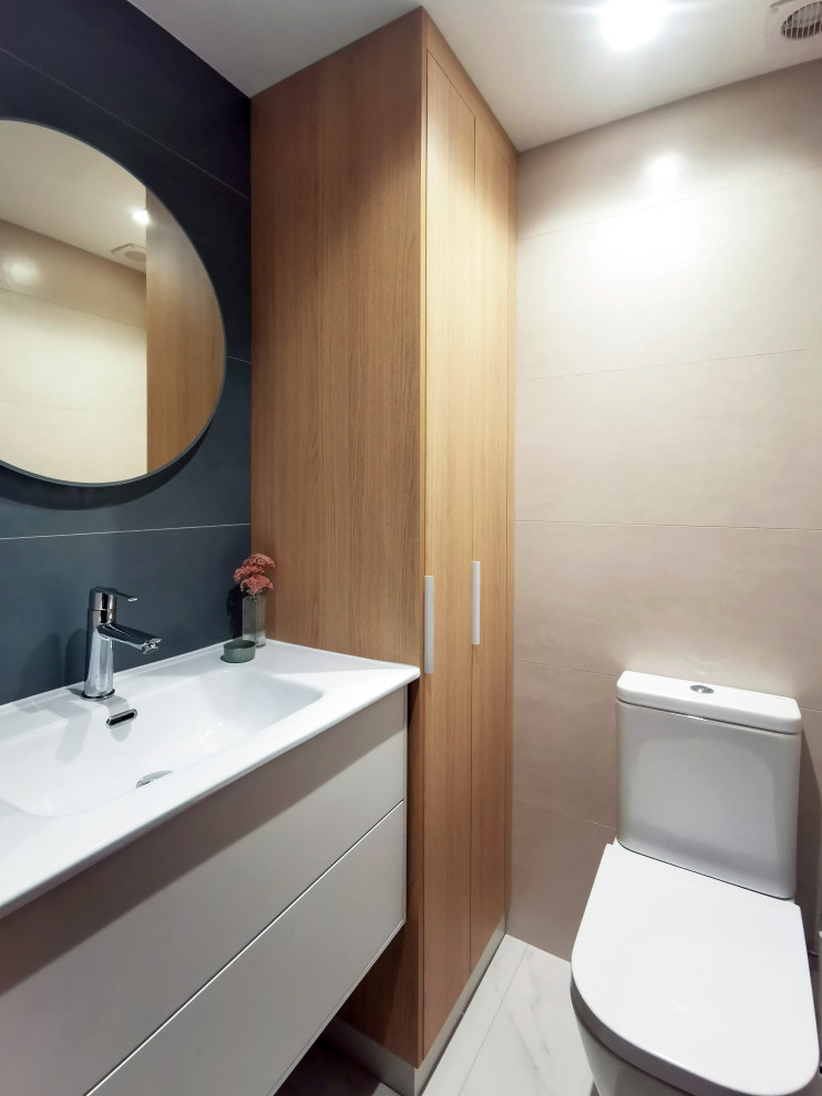 Ejemplo de aseo flotante contemporáneo pequeño con armarios con paneles lisos, puertas de armario blancas, sanitario de pared, baldosas y/o azulejos verdes, baldosas y/o azulejos de cerámica, paredes verdes, suelo de baldosas de porcelana, lavabo de seno grande, encimera de acrílico, suelo beige y encimeras blancas