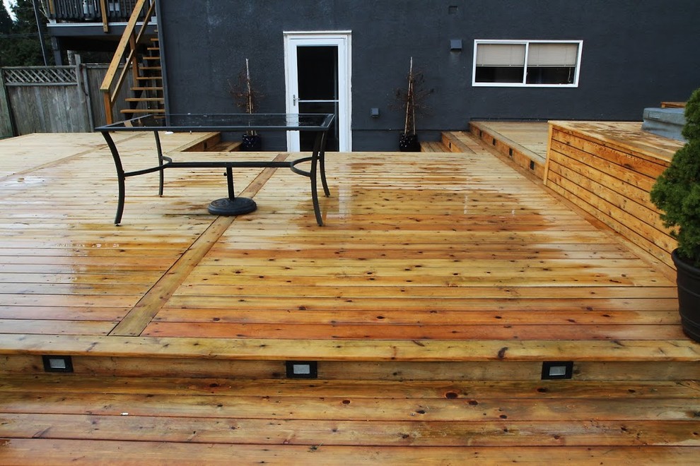 Example of a large mountain style backyard water fountain deck design in Vancouver with no cover