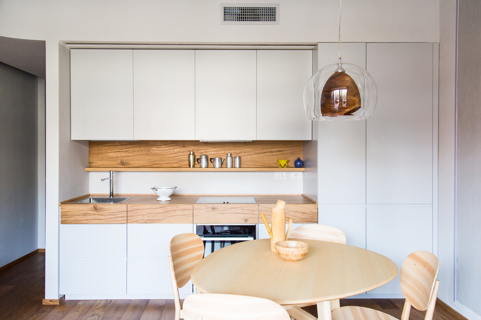 Inspiration for a mid-sized modern single-wall eat-in kitchen in Milan with a drop-in sink, flat-panel cabinets, grey cabinets, wood benchtops, brown splashback, timber splashback, medium hardwood floors, no island and brown floor.
