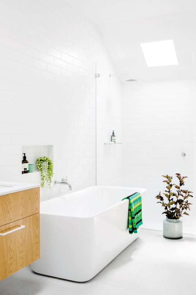 Mid-sized scandinavian master bathroom in Other with an undermount sink, medium wood cabinets, a freestanding tub, a curbless shower, white tile and white walls.