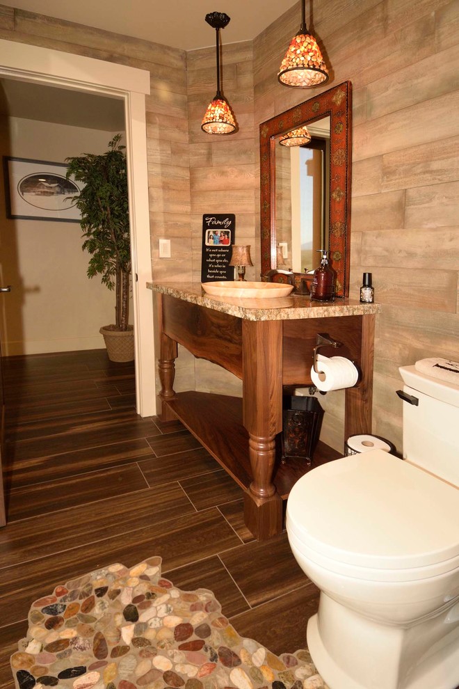 This is an example of a small country 3/4 bathroom in Other with furniture-like cabinets, dark wood cabinets, an alcove shower, a one-piece toilet, multi-coloured tile, stone tile, beige walls, cement tiles, a drop-in sink, granite benchtops, beige floor and a hinged shower door.