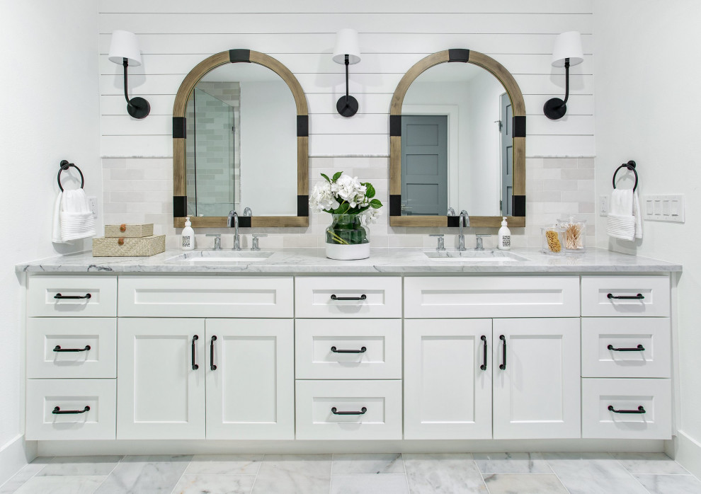 Design ideas for a mid-sized beach style master bathroom in Dallas with shaker cabinets, white cabinets, an alcove shower, white tile, marble, white walls, marble floors, an undermount sink, marble benchtops, yellow floor, a hinged shower door, white benchtops, a double vanity and a built-in vanity.