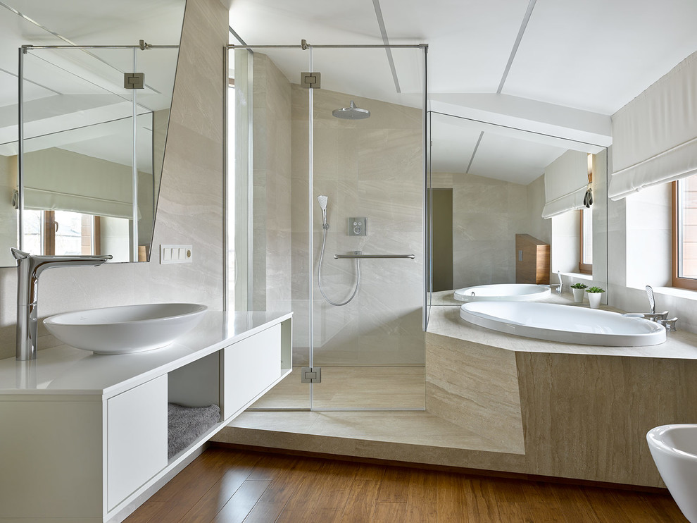 This is an example of a contemporary master bathroom in Moscow with flat-panel cabinets, white cabinets, a drop-in tub, a vessel sink, brown floor, a hinged shower door, white benchtops, a curbless shower, a bidet, beige walls and medium hardwood floors.