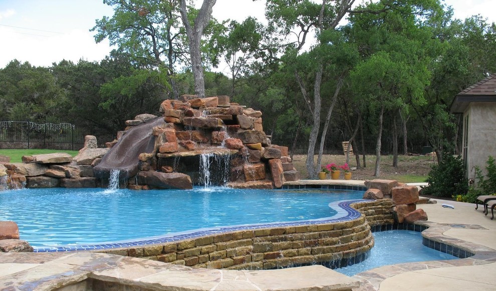 Mid-sized mountain style backyard custom-shaped natural pool fountain photo in Austin with decking