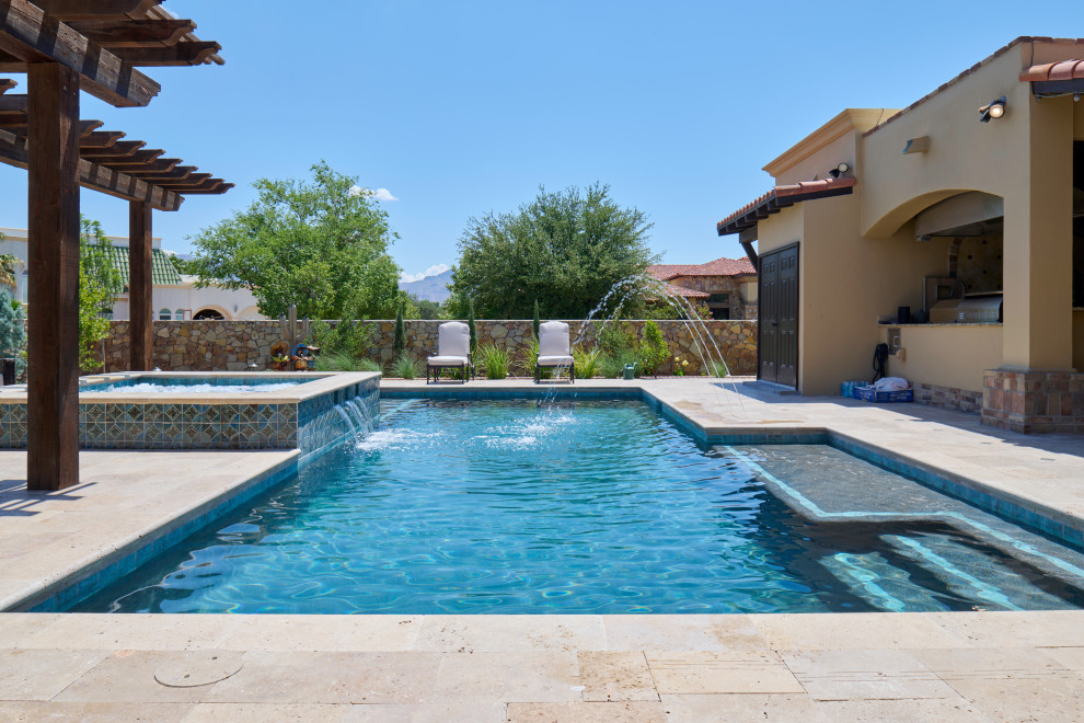 Modelo de piscina natural mediterránea de tamaño medio rectangular en patio trasero con paisajismo de piscina y adoquines de piedra natural