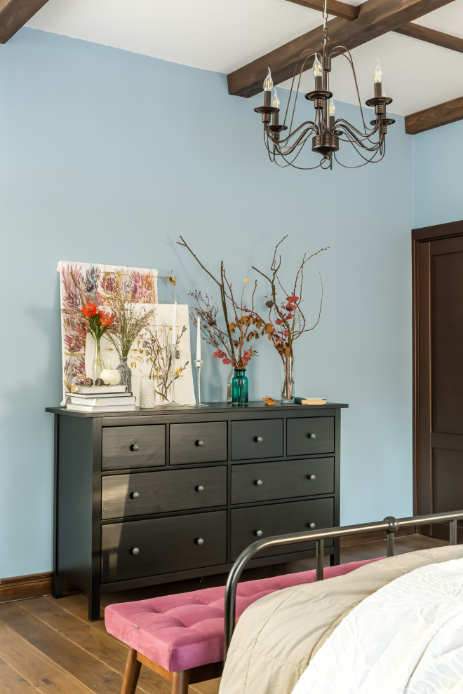 Foto de dormitorio principal de estilo de casa de campo de tamaño medio con paredes azules, suelo de madera en tonos medios, suelo marrón y vigas vistas