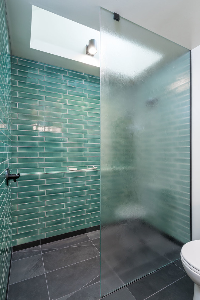 Photo of a small modern wet room bathroom in Portland with flat-panel cabinets, light wood cabinets, a two-piece toilet, green tile, ceramic tile, white walls, slate floors, an undermount sink, concrete benchtops, black floor, grey benchtops and an open shower.