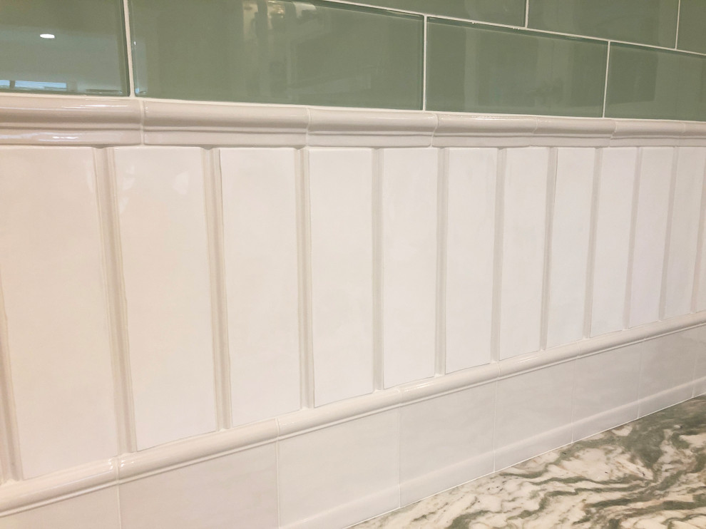 Example of a mid-sized transitional u-shaped light wood floor kitchen design with glass-front cabinets, white cabinets, marble countertops, green backsplash, glass tile backsplash, stainless steel appliances and green countertops
