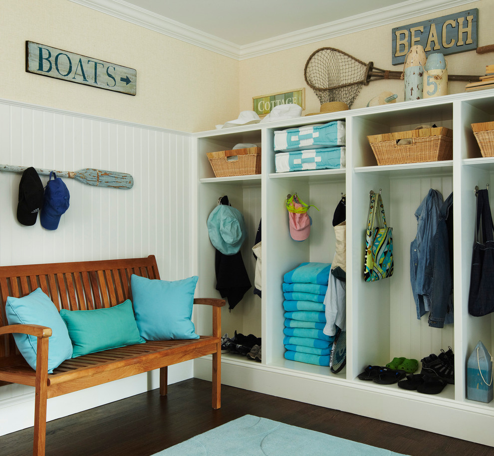 Design ideas for a mid-sized beach style mudroom in New York with yellow walls and dark hardwood floors.
