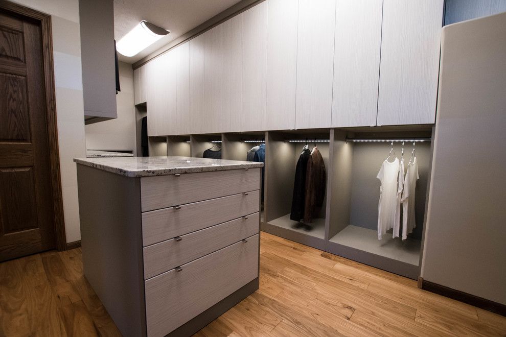 Inspiration for a large contemporary gender-neutral walk-in wardrobe in Other with flat-panel cabinets and medium hardwood floors.