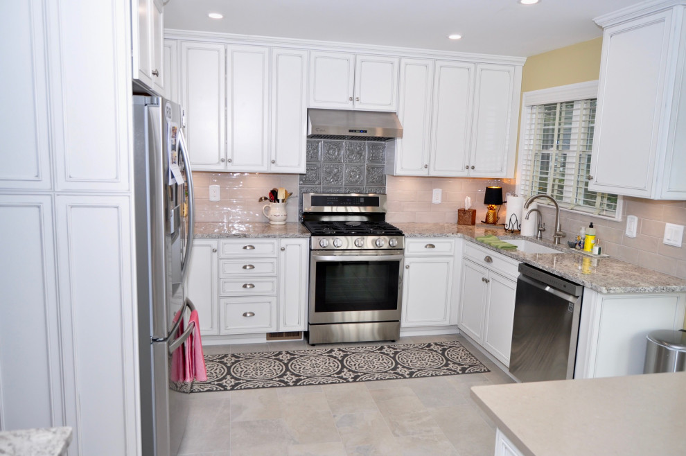 This is an example of a mid-sized transitional eat-in kitchen in New York with a single-bowl sink, beaded inset cabinets, beige cabinets, granite benchtops, beige splashback, porcelain splashback, stainless steel appliances, porcelain floors, with island, beige floor and multi-coloured benchtop.