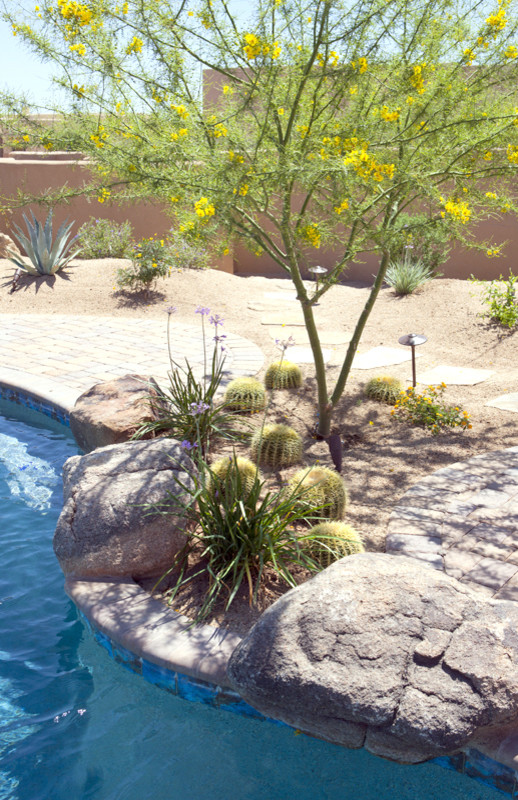 Home design - rustic backyard concrete paver and freeform natural home design idea in Phoenix