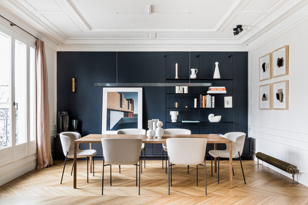 Design ideas for a mid-sized contemporary open plan dining in Paris with white walls, light hardwood floors, no fireplace, beige floor and decorative wall panelling.