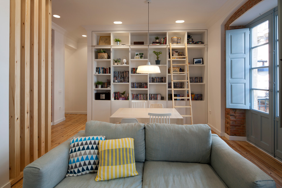 Foto de comedor nórdico de tamaño medio abierto sin chimenea con paredes blancas y suelo de madera en tonos medios