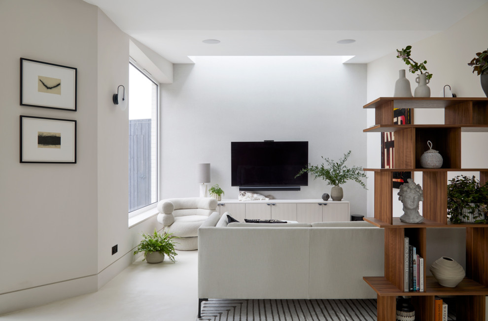 Modelo de salón abierto contemporáneo extra grande con paredes beige, suelo de cemento, televisor colgado en la pared y suelo beige