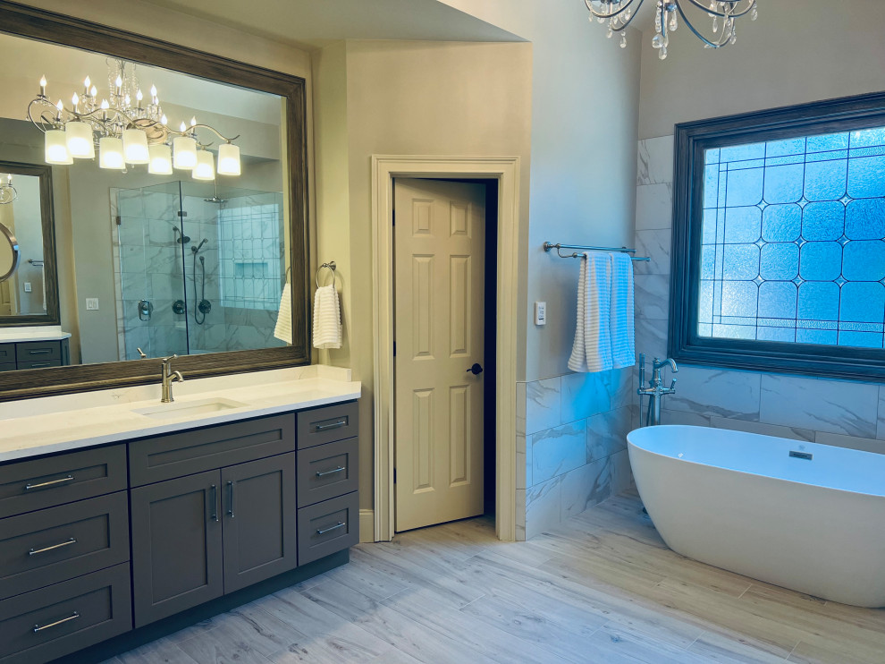 Exempel på ett stort klassiskt vit vitt en-suite badrum, med skåp i shakerstil, beige skåp, ett fristående badkar, en hörndusch, en toalettstol med hel cisternkåpa, vit kakel, beige väggar, ett undermonterad handfat, bänkskiva i kvarts, grått golv och dusch med gångjärnsdörr