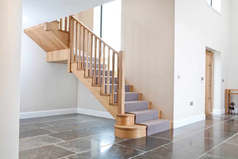 Photo of a large modern wood l-shaped staircase in Other with wood risers and wood railing.