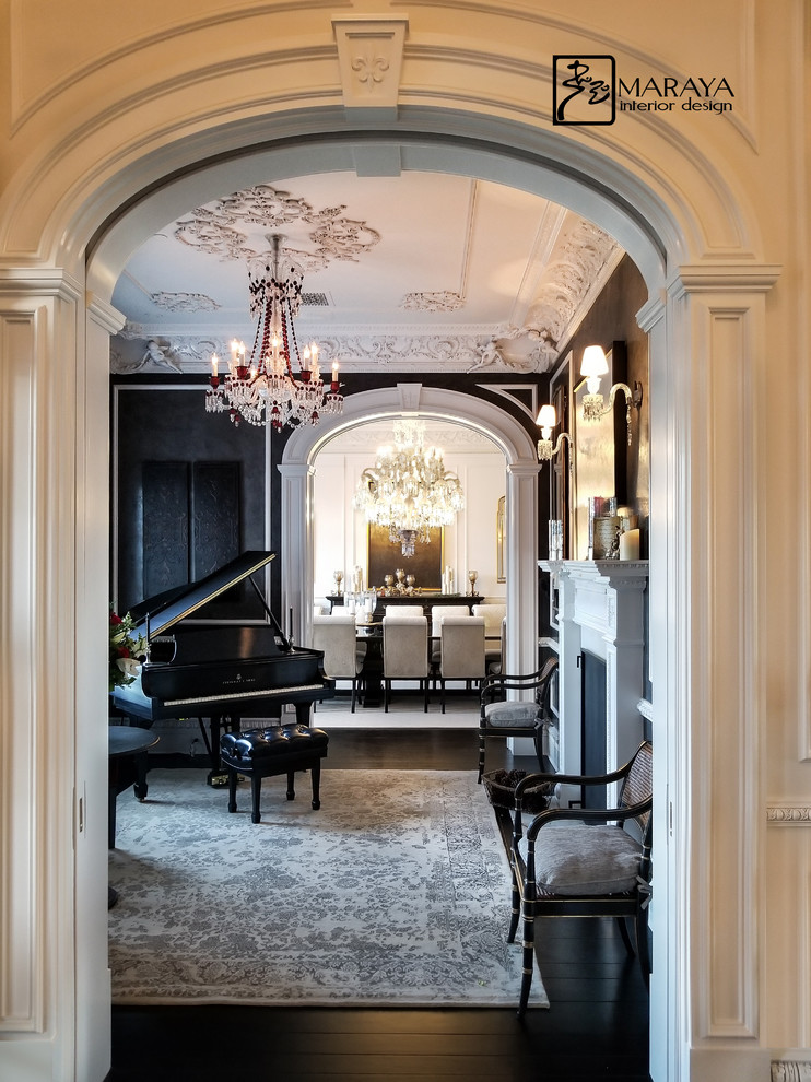Photo of a mid-sized traditional foyer with black walls, dark hardwood floors and black floor.