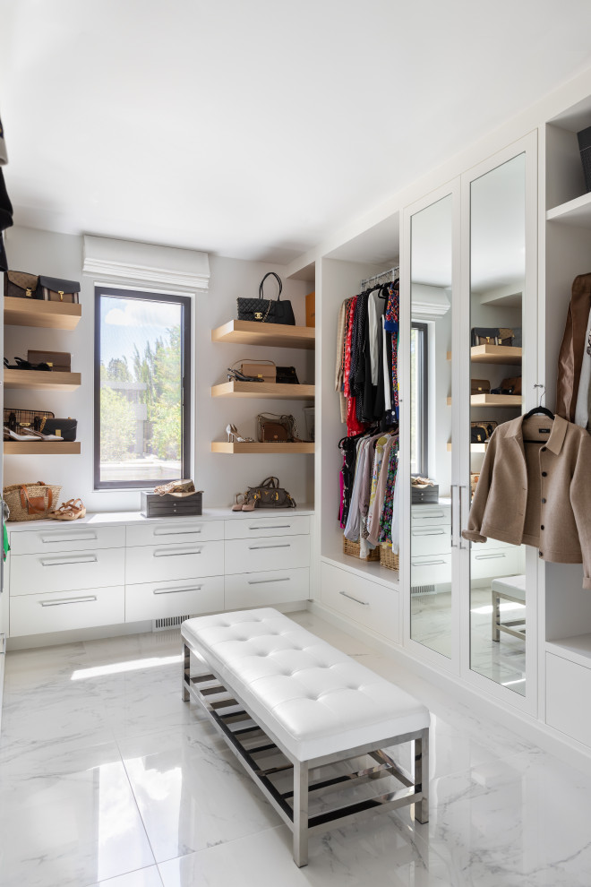 Inspiration for a large modern walk-in closet remodel in Calgary with flat-panel cabinets and white cabinets