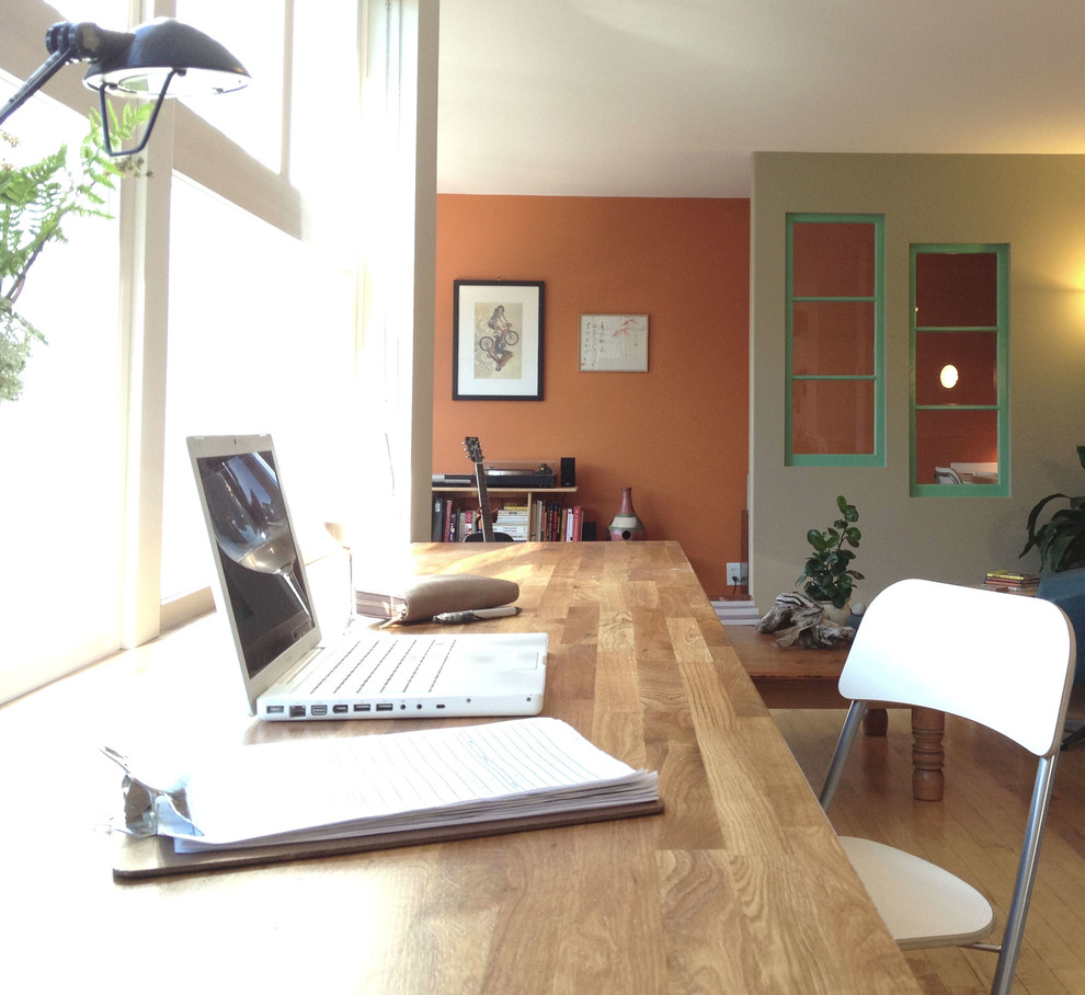 Design ideas for a small contemporary home office in Calgary with orange walls and a built-in desk.