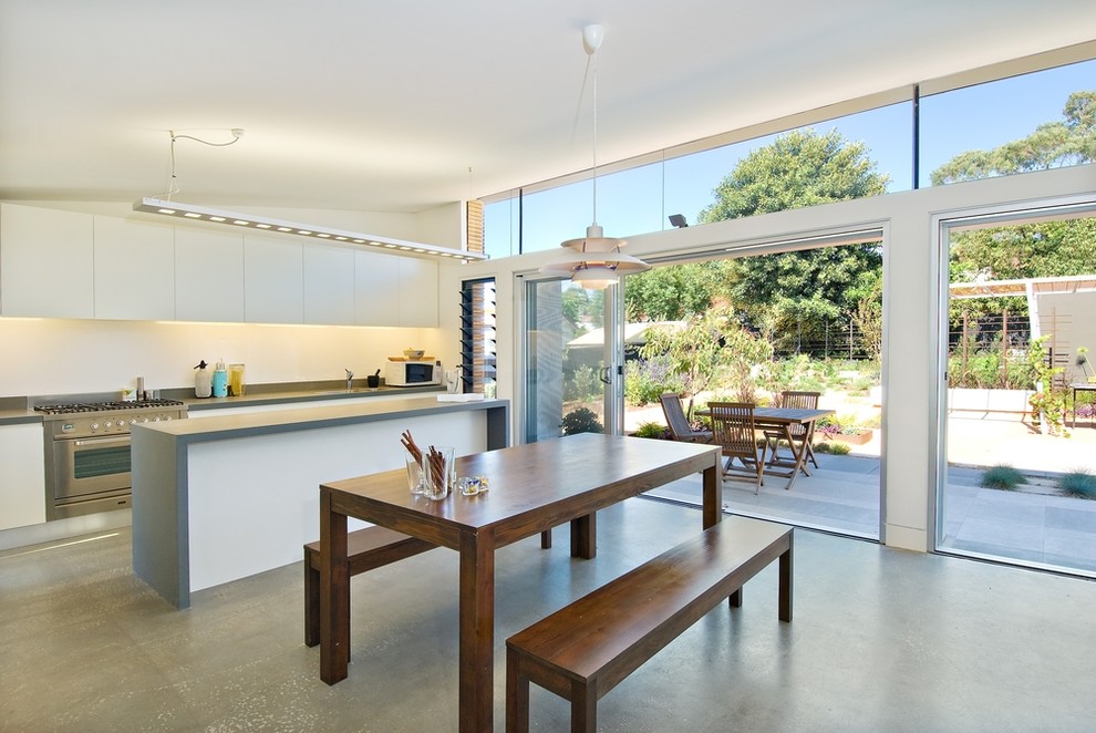 Design ideas for a contemporary kitchen/dining combo in Sydney with white walls, concrete floors and grey floor.