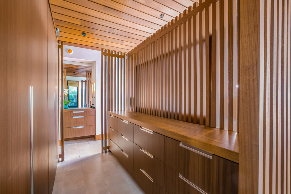 Inspiration for a mid-sized modern gender-neutral walk-in wardrobe in Hawaii with flat-panel cabinets, medium wood cabinets, ceramic floors and grey floor.