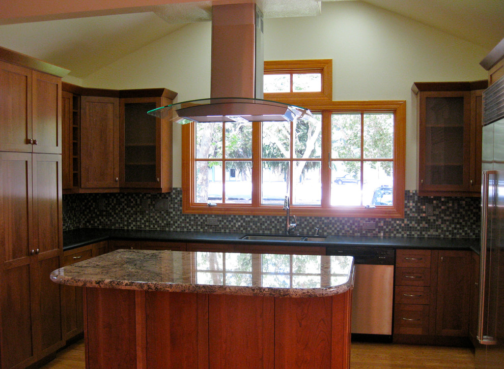 Photo of a traditional u-shaped open plan kitchen in San Francisco with an undermount sink, recessed-panel cabinets, medium wood cabinets, soapstone benchtops, multi-coloured splashback and stainless steel appliances.