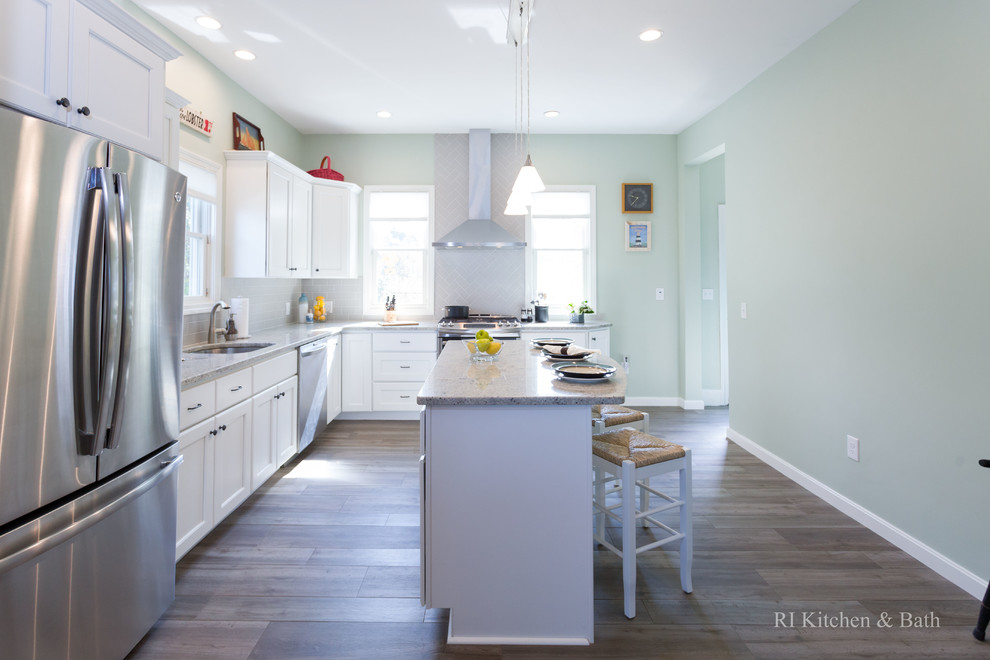 Large transitional l-shaped porcelain tile eat-in kitchen photo in Providence with an undermount sink, recessed-panel cabinets, white cabinets, granite countertops, gray backsplash, ceramic backsplash, stainless steel appliances, green walls and an island