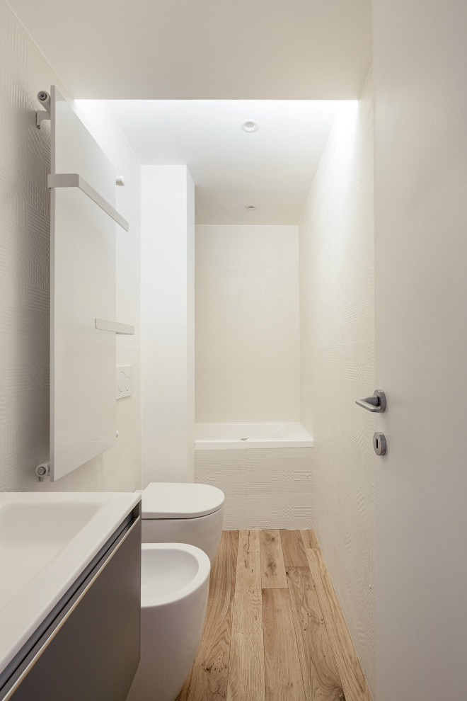 Свежая идея для дизайна: главная ванная комната среднего размера в скандинавском стиле с плоскими фасадами, серыми фасадами, гидромассажной ванной, инсталляцией, белыми стенами, светлым паркетным полом, белой столешницей, тумбой под одну раковину и подвесной тумбой - отличное фото интерьера
