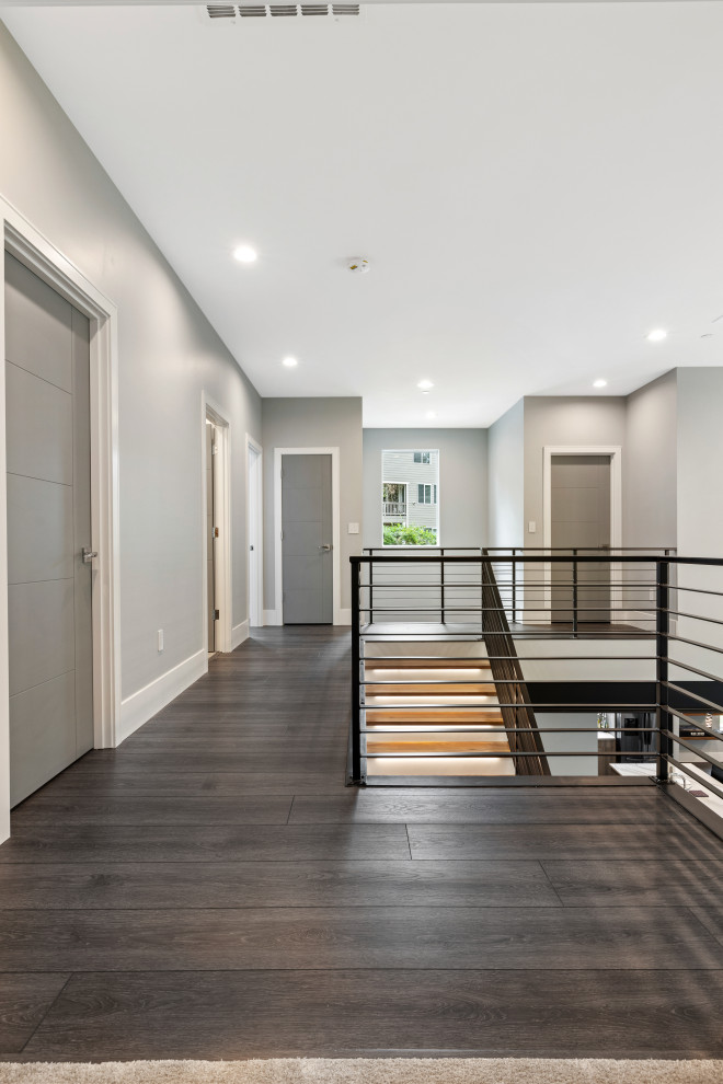 Example of a mid-sized minimalist vinyl floor, gray floor and vaulted ceiling hallway design with gray walls