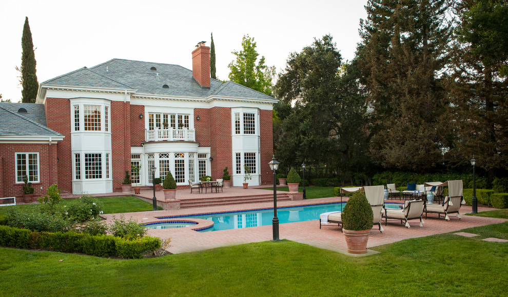 Inspiration for a large transitional backyard brick and rectangular pool remodel in Los Angeles