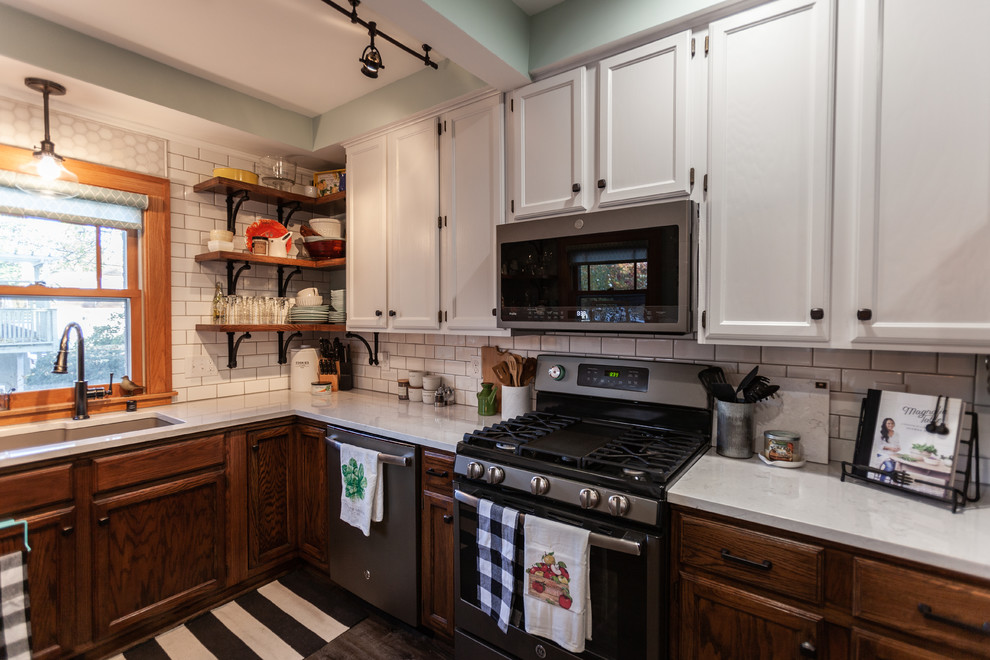 Mid-sized traditional u-shaped eat-in kitchen in Minneapolis with an undermount sink, shaker cabinets, medium wood cabinets, quartz benchtops, white splashback, subway tile splashback, stainless steel appliances, vinyl floors, a peninsula, grey floor and white benchtop.