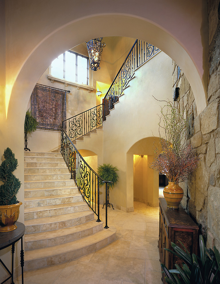 Inspiration for a traditional travertine u-shaped staircase in Austin with travertine risers and metal railing.