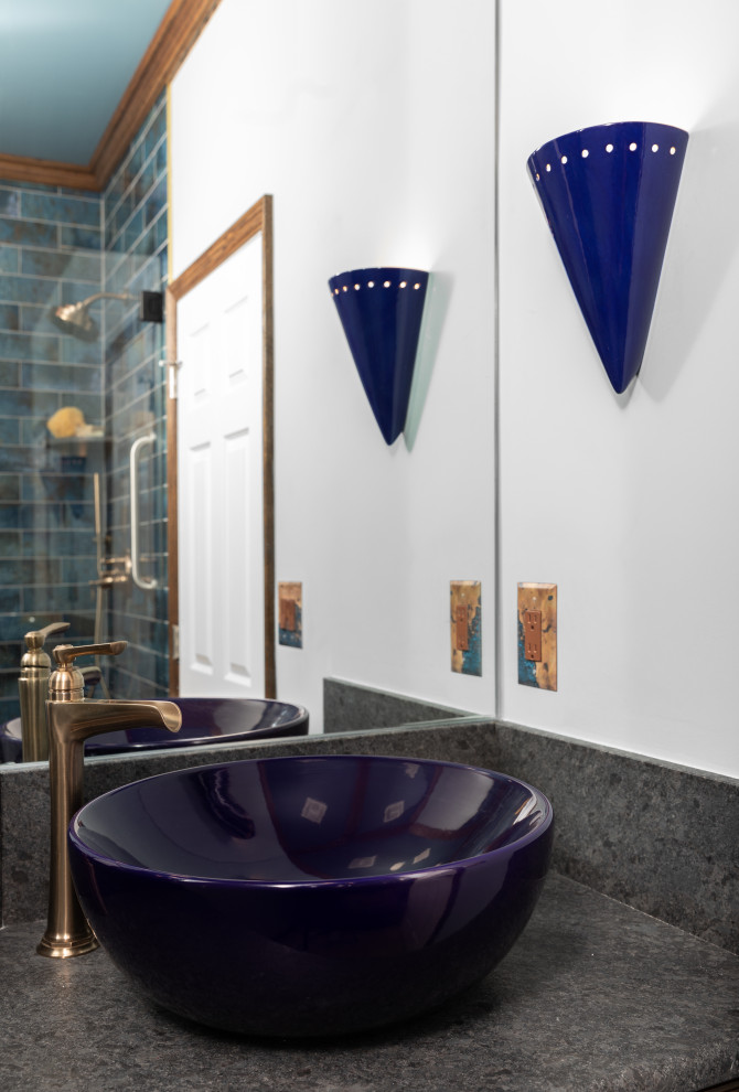 Cette image montre une petite douche en alcôve sud-ouest américain en bois foncé avec un placard avec porte à panneau surélevé, un carrelage bleu, des carreaux de porcelaine, un mur bleu, un sol en carrelage de porcelaine, une vasque, un plan de toilette en granite, un sol marron, une cabine de douche à porte battante, un plan de toilette gris, un banc de douche, meuble simple vasque et meuble-lavabo encastré.