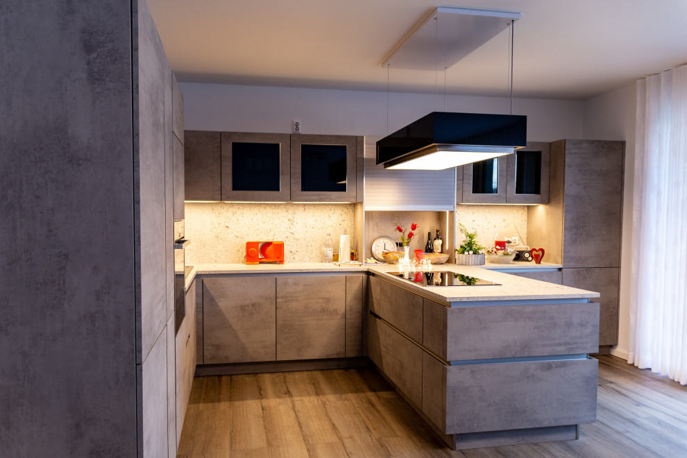 Küche in U-Form mit Einbauwaschbecken, Glasfronten, grauen Schränken, Arbeitsplatte aus Holz, Küchenrückwand in Grau, Rückwand aus Holz, schwarzen Elektrogeräten, Keramikboden, Halbinsel, braunem Boden, grauer Arbeitsplatte und Tapetendecke in Dusseldorf