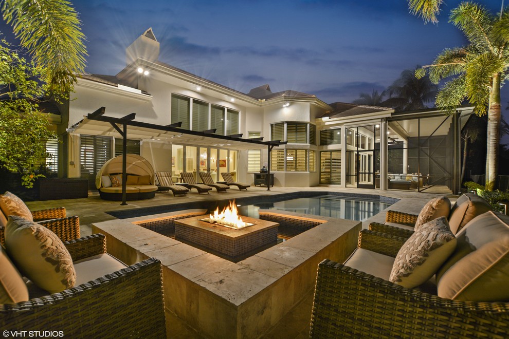 Mid-sized transitional backyard stone and custom-shaped pool photo in Miami