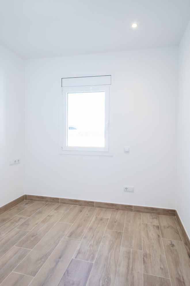 バルセロナにある中くらいな地中海スタイルのおしゃれな主寝室 (白い壁、セラミックタイルの床、暖炉なし、茶色い床) のインテリア